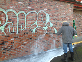 Power Washer removing graffiti from a building in Eugene, Springfield Oregon